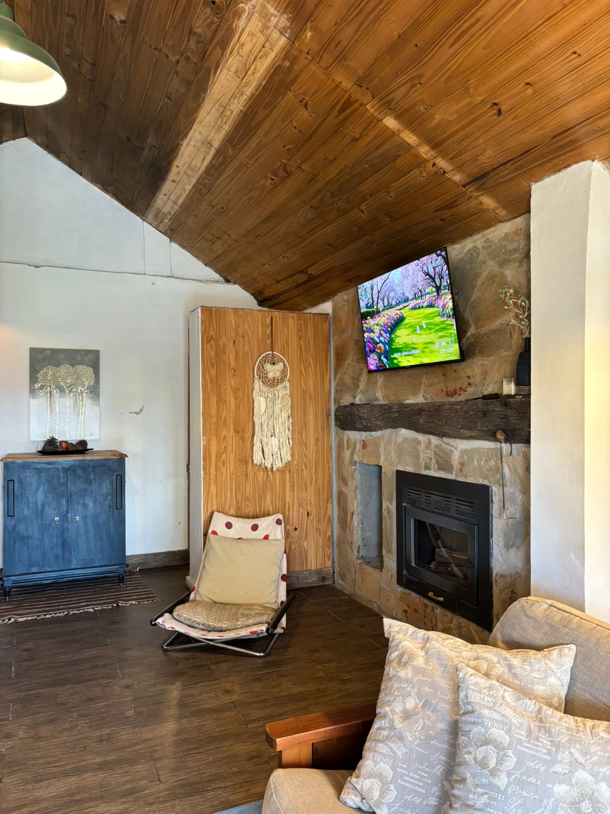 Hogar a leña revestido en piedra y Smart TV