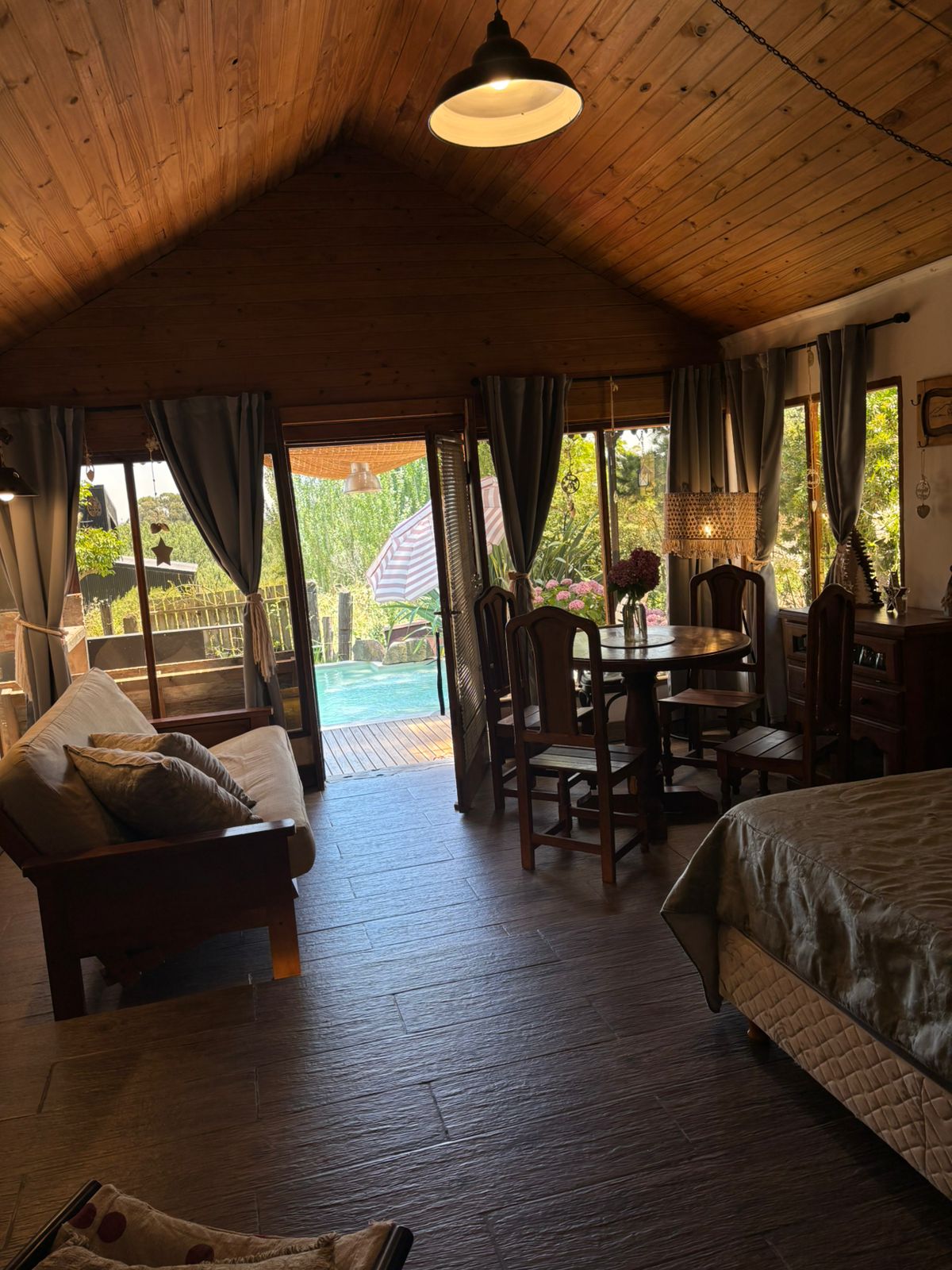Interior cálido de la cabaña con vista al deck y la pileta