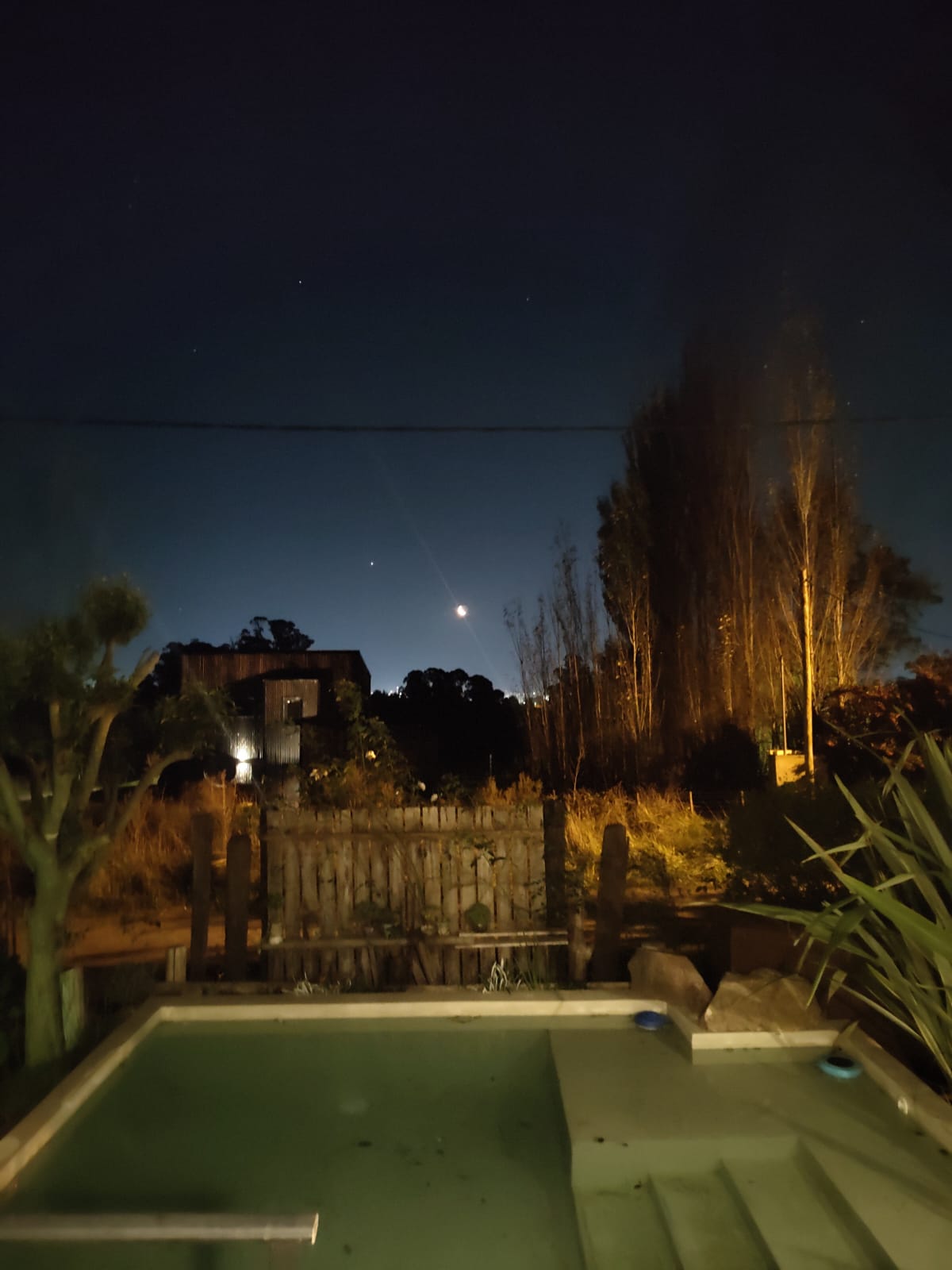 Pileta de la cabaña bajo el cielo nocturno y la luna